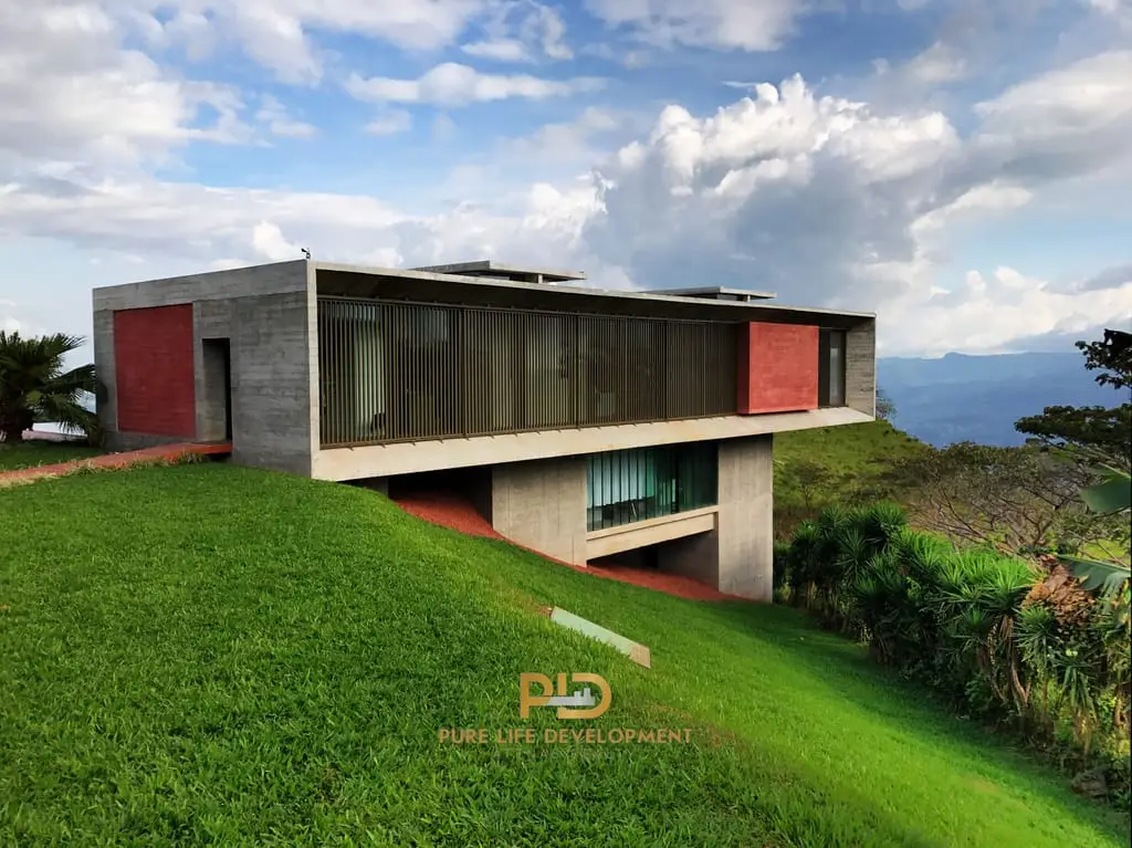 Modern concrete house on lush hillside