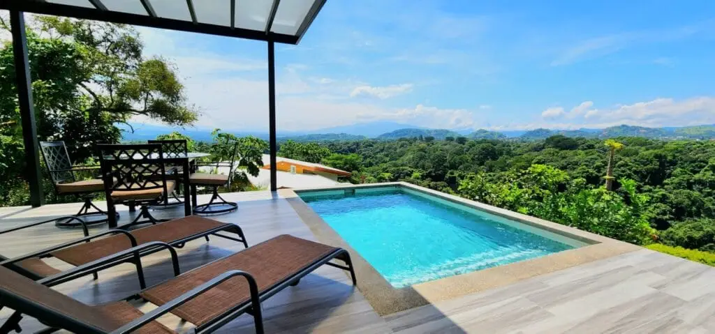 Scenic patio with pool and forest view.