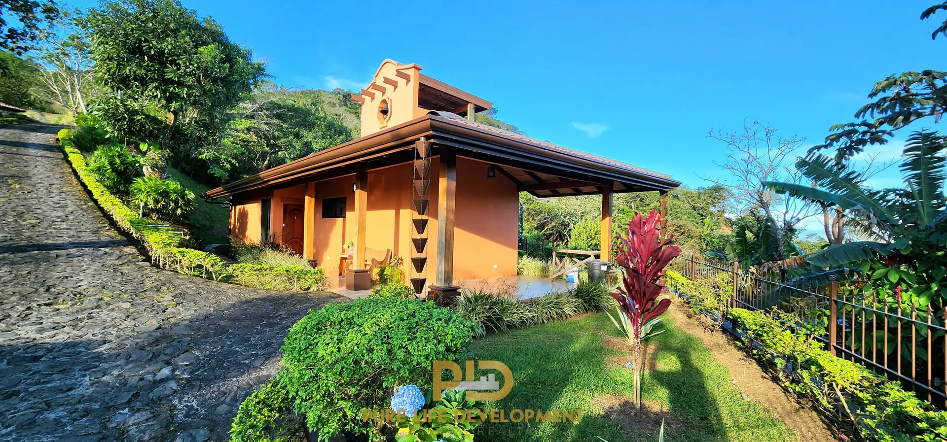 Small orange house in tropical garden setting