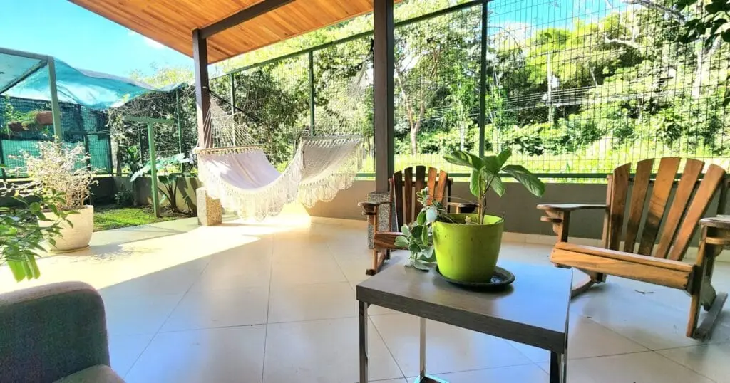 Sunny porch with hammock and wooden chairs