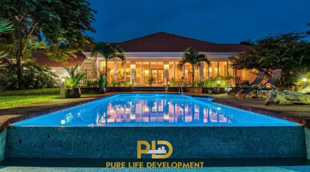 Luxury ranch-style estate near Atenas, Costa Rica, with illuminated pool at night. For sale by PLD Atenas Realty.