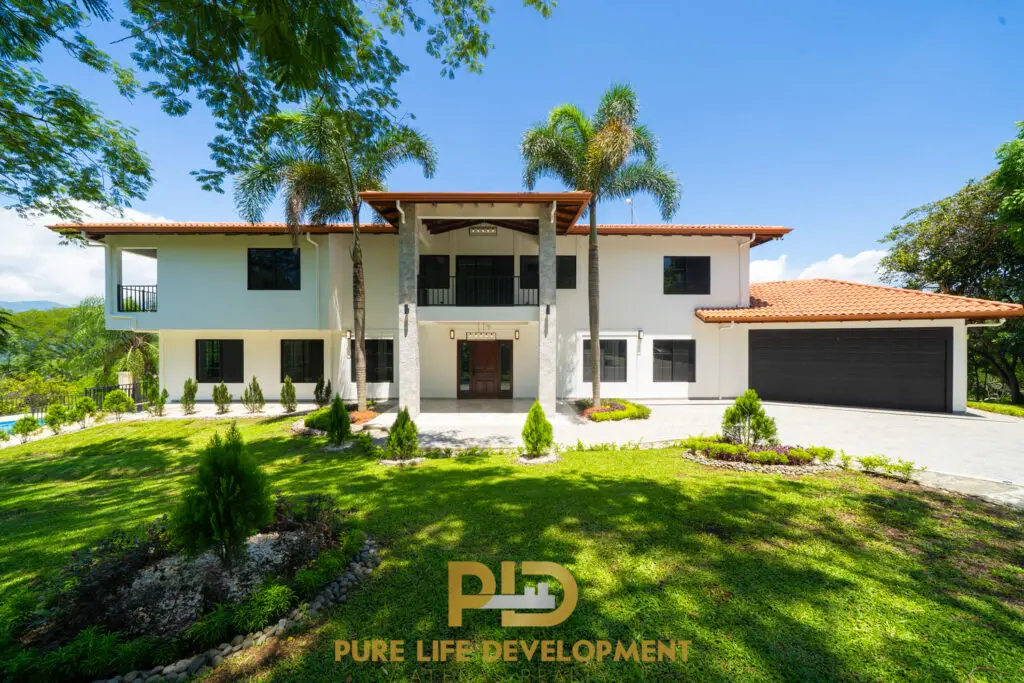 Luxurious house with greenery and blue sky.