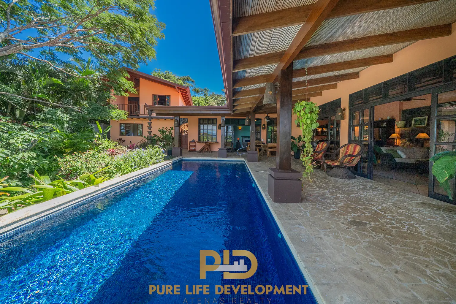 Modern house with blue pool and lush greenery.