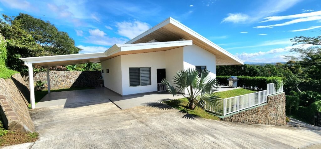 Modern white house with slanted roof.