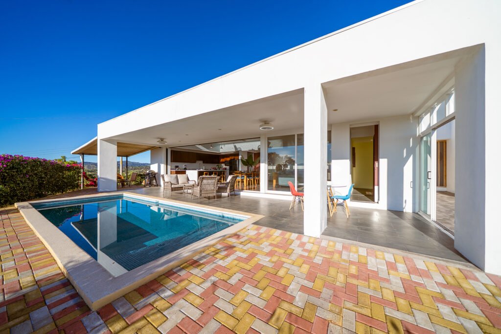 Modern patio with pool and outdoor seating.