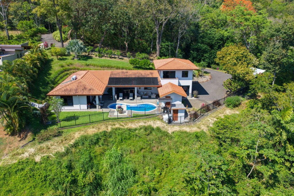 Aerial view of modern hillside home with pool