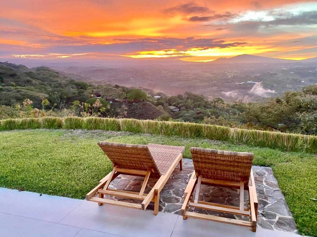 Lounge chairs overlooking mountain valley at sunset