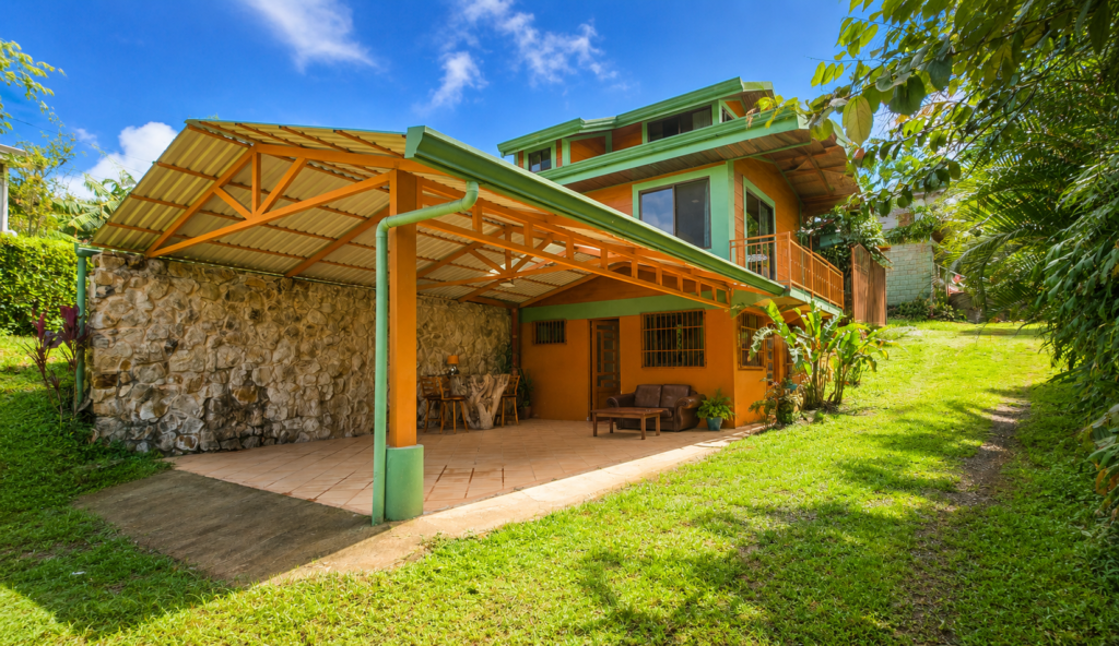 Colorful tropical house with covered patio and lawn