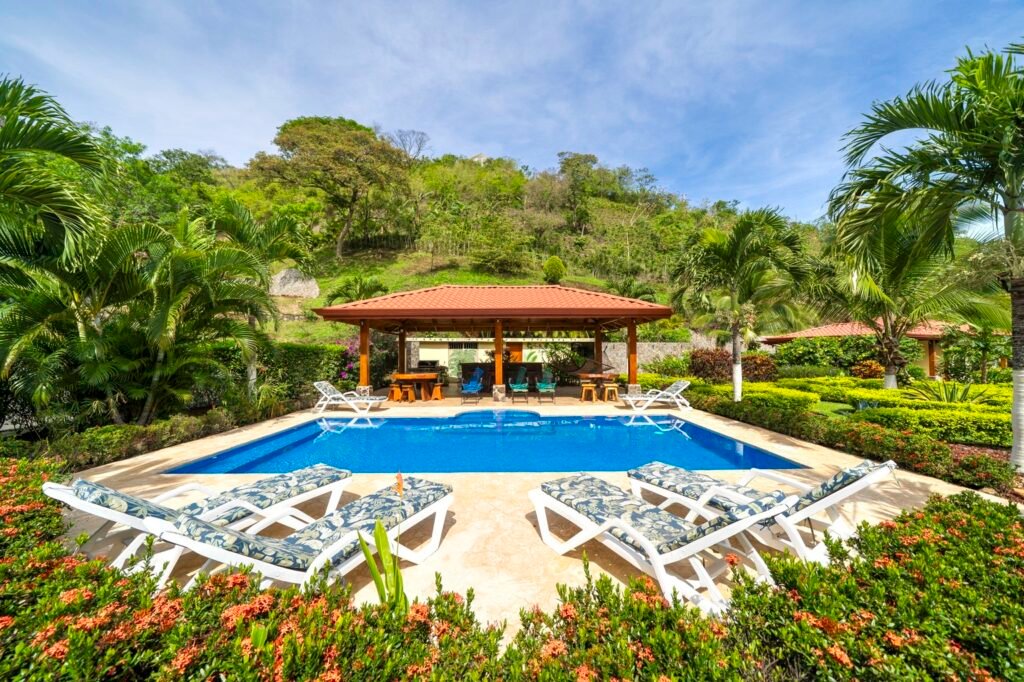 Tropical villa pool with lounge chairs and palm trees