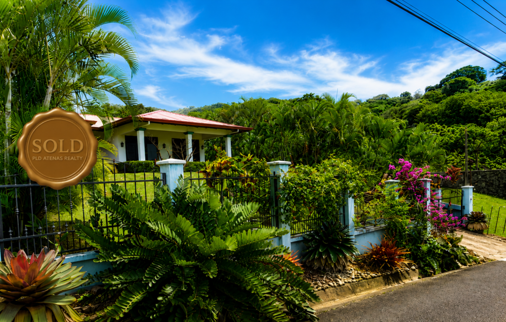 Tropical home with lush garden and sold sign