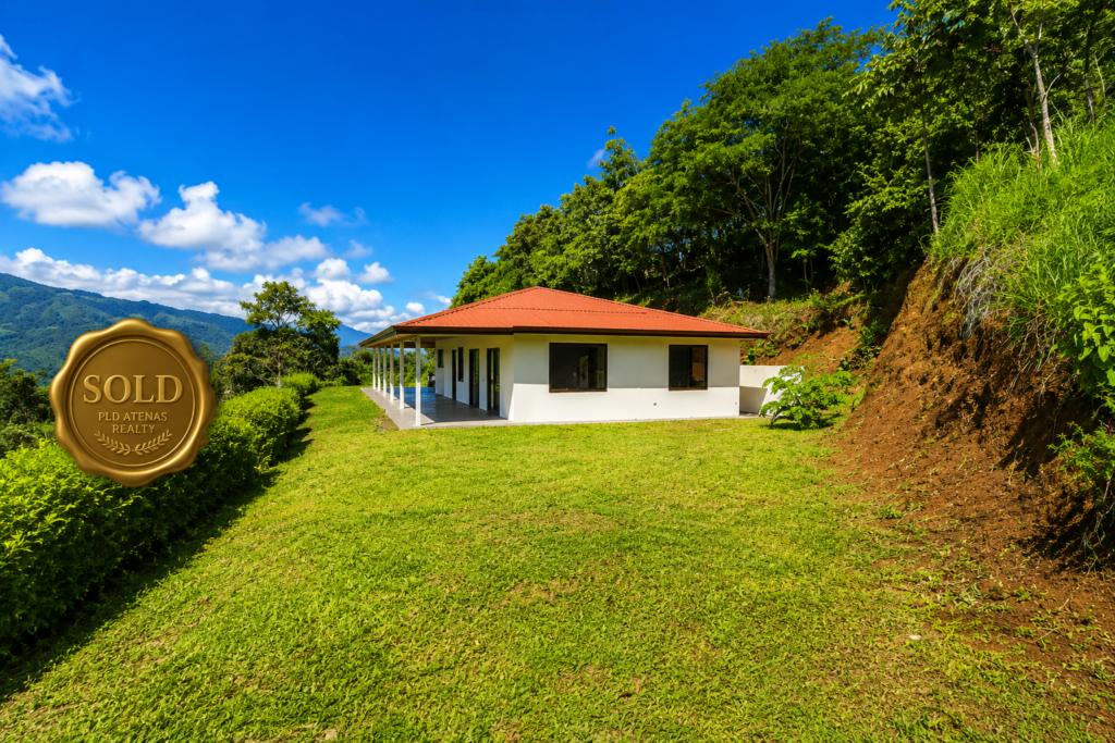 Modern hillside home with red roof and lawn