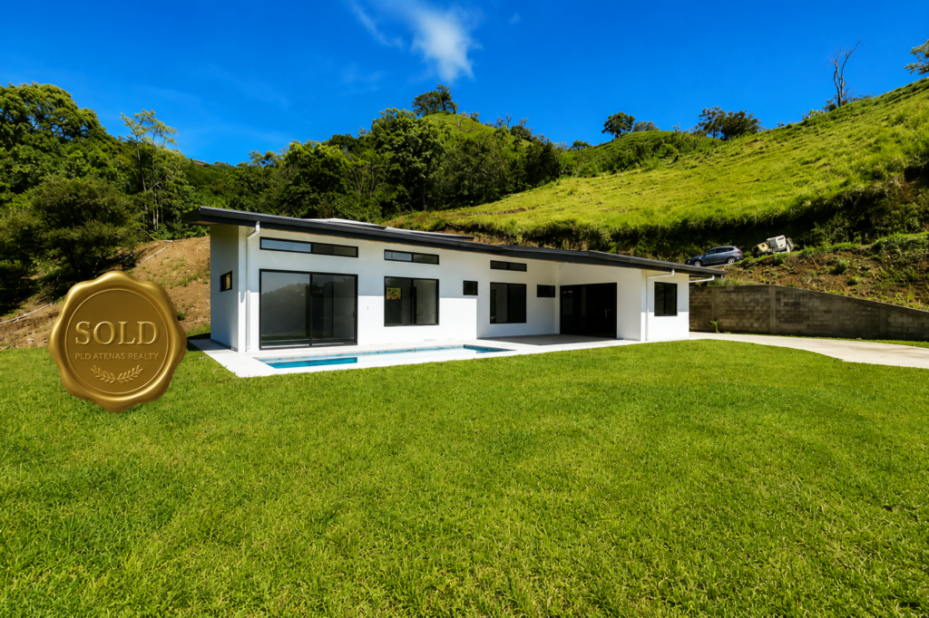 Modern white home with lawn and sold seal
