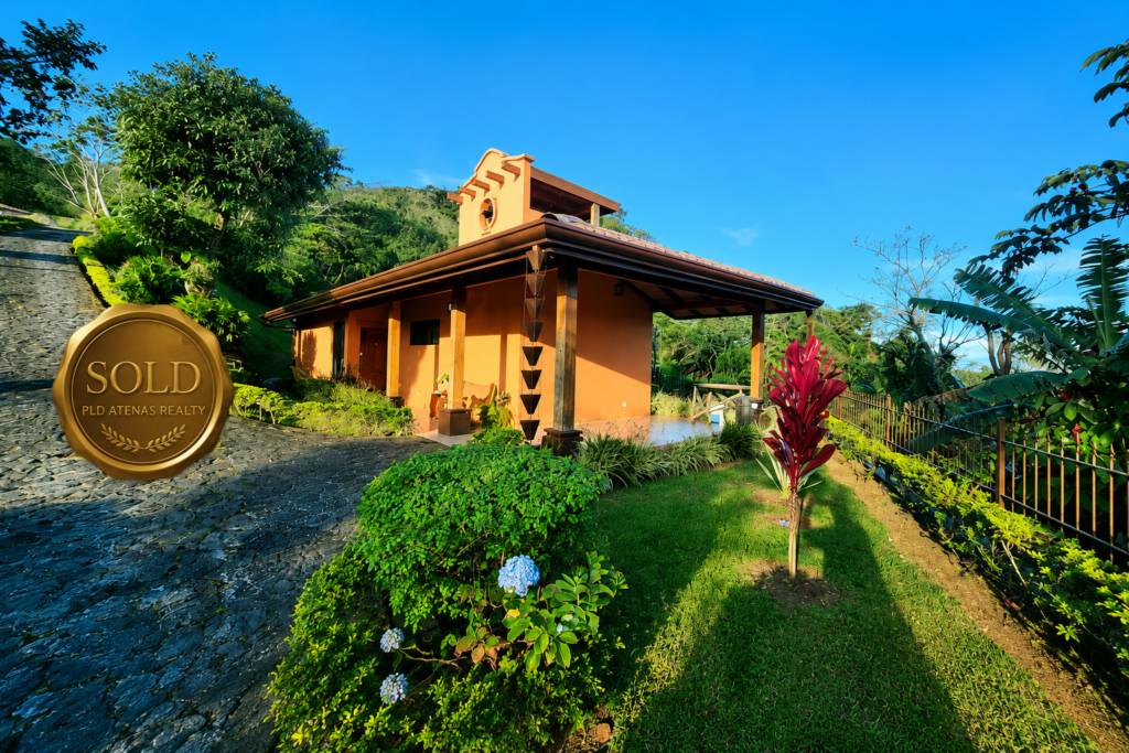 Tropical hillside home with sold realty badge