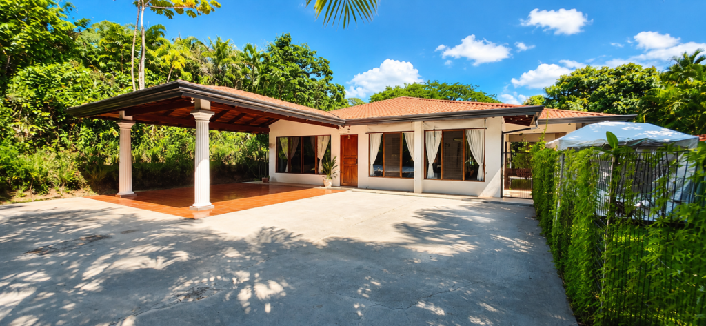 Tropical single-story home with covered patio and driveway