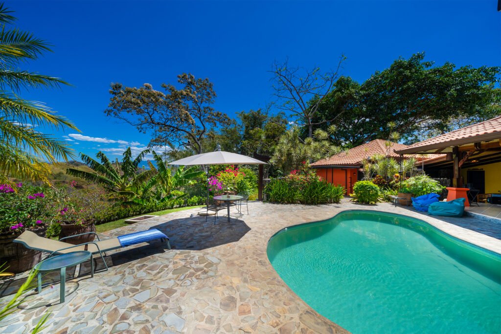 Tropical villa patio with pool and lush garden
