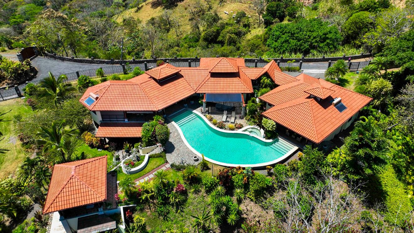 Aerial view of luxury villa with curved pool
