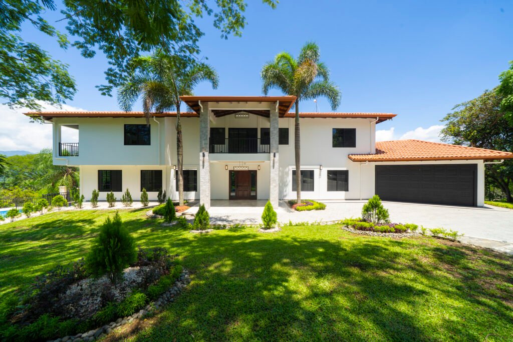 Modern two-story house with palm trees and lawn