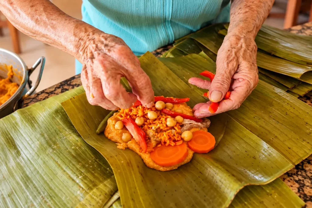 Hands assembling rice filling on banana leaf